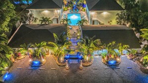 Een resort met een centraal gelegen zwembad, meerdere gastenkamers en een goed onderhouden tuin.