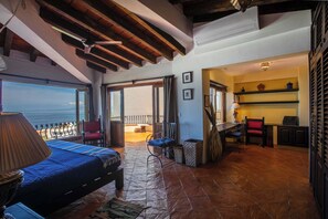 Ein geräumiges Zimmer mit Bett, Schreibtisch und Meerblick.