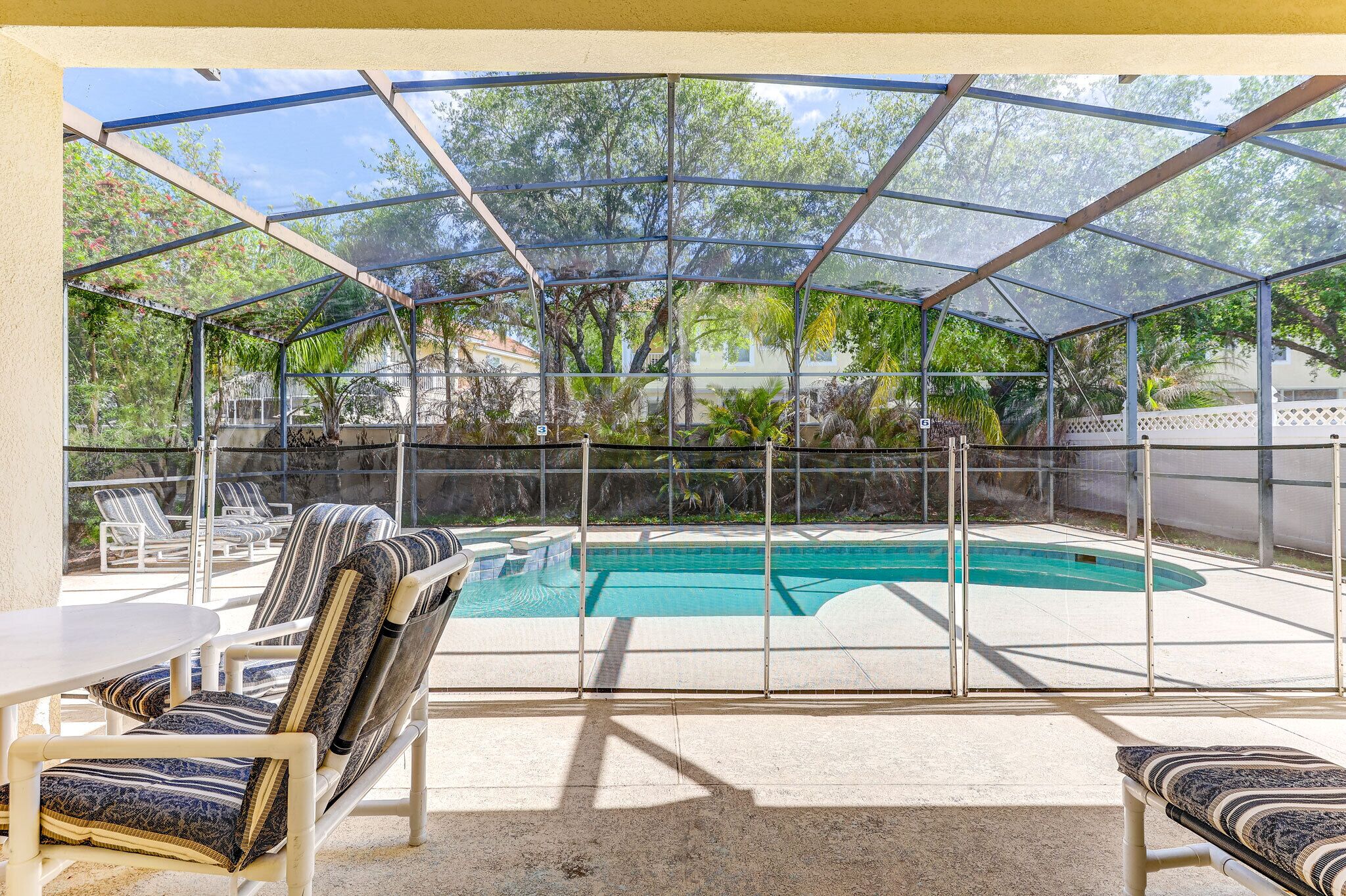 Ett takförsett utomhusområde med en pool, solstolar och ett bord.