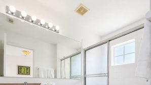 Un bagno con un lavabo, il water e una cabina doccia con porta in vetro.