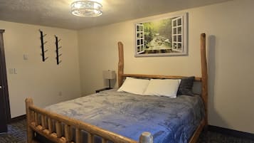 Una camera da letto con un letto di legno, un quadro che raffigura un paesaggio e una lampada a soffitto.