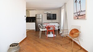 A compact living space with a kitchenette, dining area, and a TV mounted on the wall. - Agréable et Cosy - Suquet - proche des plages (Cannes)