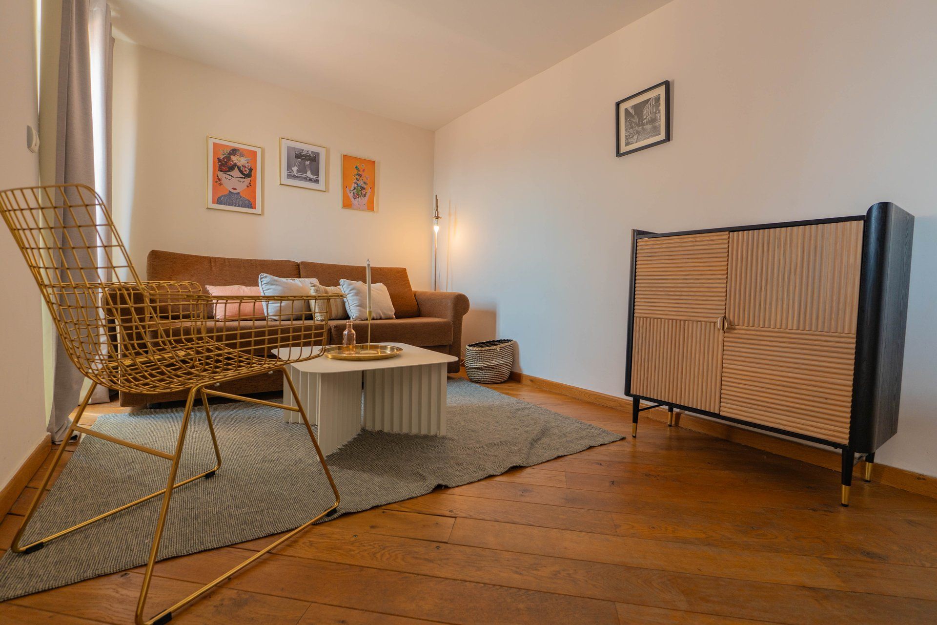 Un salon comprenant un canapé, une table basse, un fauteuil et un meuble.