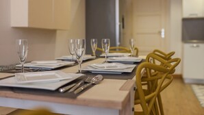 A dining area with a long table set for six, including plates, cutlery, and wine glasses. - Agréable et Cosy - Suquet - proche des plages (Cannes)