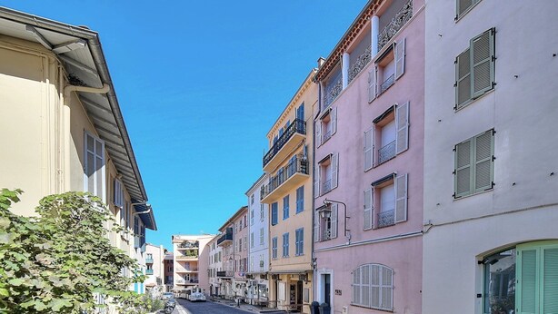 A narrow cobblestone street lined with multi-story buildings, some with balconies and shutters. - Agréable et Cosy - Suquet - proche des plages (Cannes)