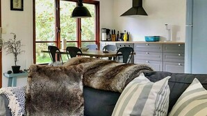 Una sala de estar moderna con un sofá, un comedor y una cocina.