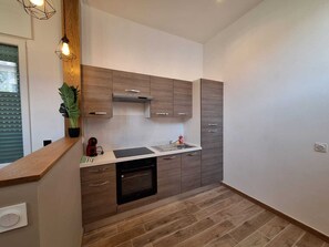 Eine moderne Küche mit Holzausstattung, einem eingebauten Backofen und einer Arbeitsplatte mit Spüle.