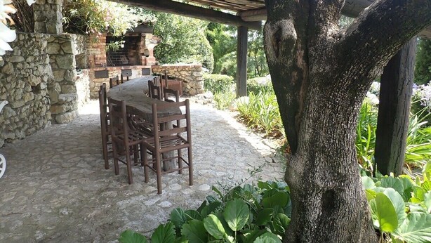 An outdoor patio with a stone table and chairs, a pergola, and a stone wall. - Authentic & Atypical house - Vence (Vence)