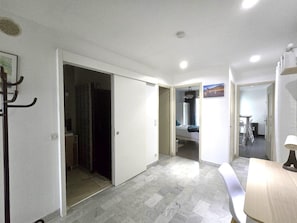Ein Hotelzimmer mit Bett, Schreibtisch, Stuhl und einem durchgegangenen Tür sichtbaren Badezimmer.