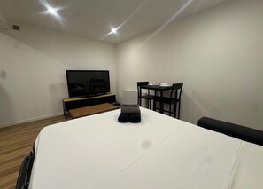 Ein Hotelzimmer mit Bett, Fernseher, Schreibtisch und Stuhl.