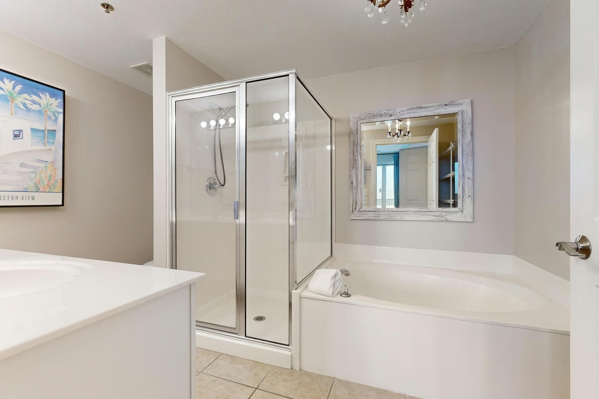 A modern bathroom with a glass-enclosed shower, a large mirror, and a bathtub.