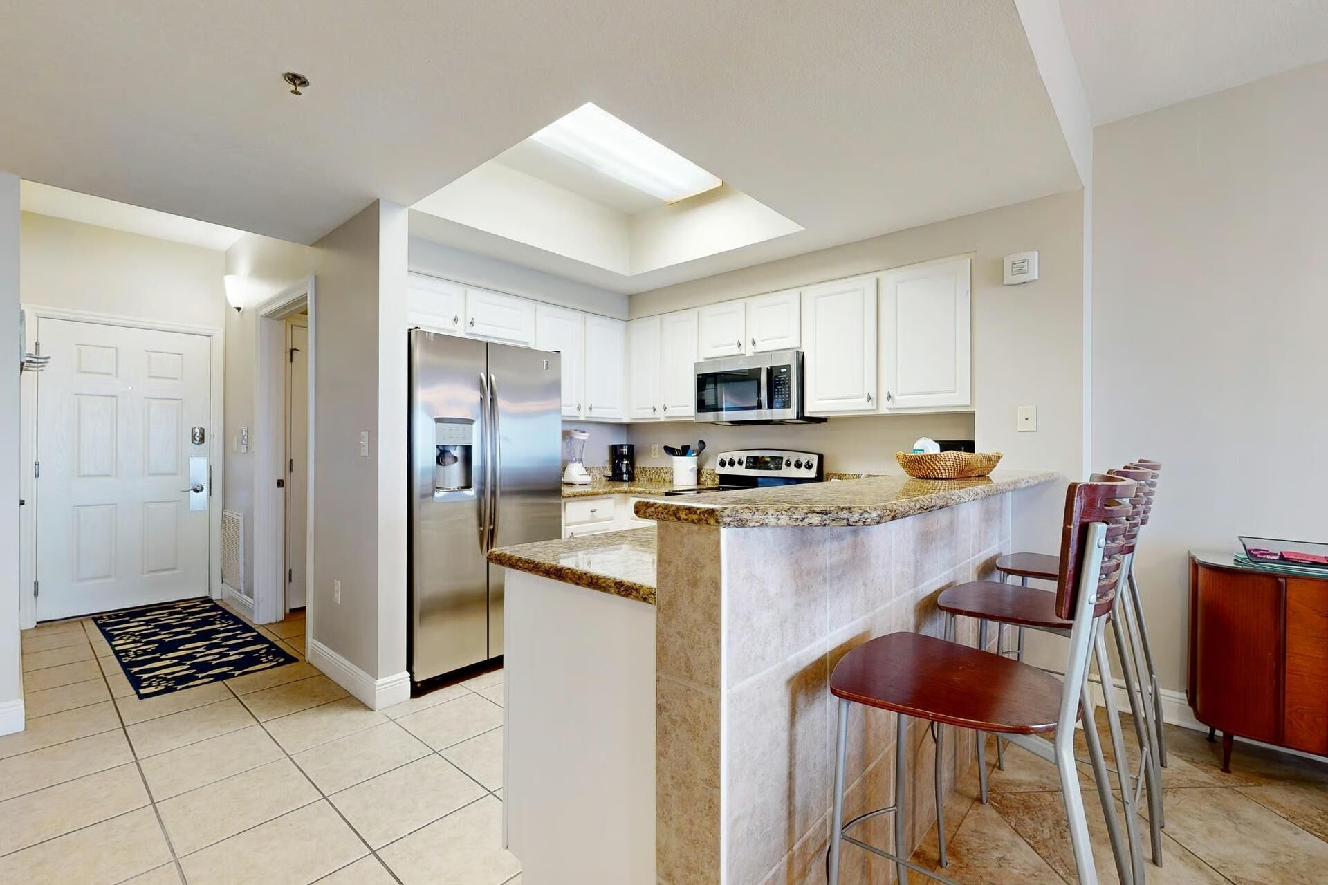 A modern kitchen with a central island, stainless steel appliances, and a breakfast bar.
