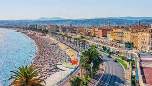 Paesaggio costiero con spiaggia, edifici e cielo sereno.