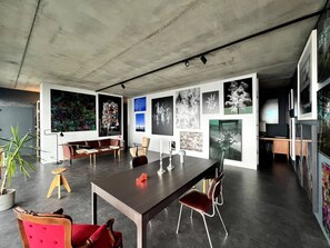 Ein modernes Interieur mit einem Esstisch, Stühlen, einer Couch und einer Topfpflanze.