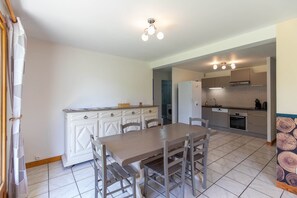 Eine Küche mit Esstisch, Stühlen, Schränken und einem eingebauten Backofen.