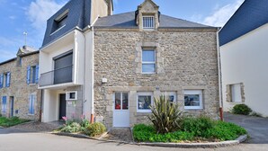 A stone building with a balcony, a door, and a window. - L’Escale morbihannaise – Appt à 15 min de la plage (Muzillac)
