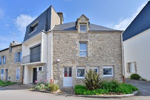 Un bâtiment en pierre doté d’un balcon, d’une porte et d’une fenêtre.