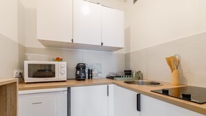 Eine kleine Küche mit Mikrowelle, Kaffeemaschine und Geschirrspüler.