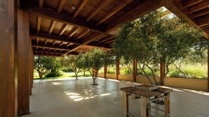 Un pavillon ouvert avec un plafond en bois et une table sur laquelle sont disposées des noix.
