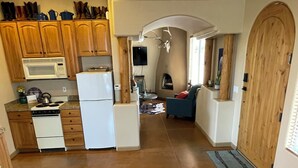 Eine Küche mit Holzausstattung, einer Mikrowelle, einem Herd und einem Kühlschrank.