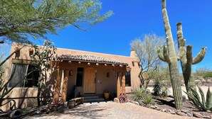 Ein traditionelles Gebäude im Pueblo-Stil mit Ziegeldach, Holztür und gepflastertem Eingang.