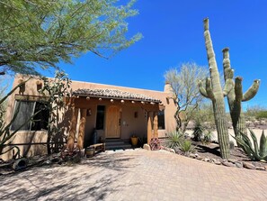 Ein traditionelles Gebäude im Pueblo-Stil mit Ziegeldach, Holztür und gepflastertem Eingang.