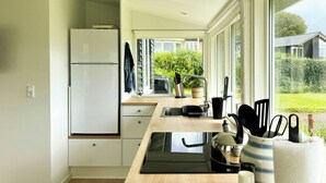 Eine moderne Küche mit Einbauherd, Spüle und Fenster mit Blick auf einen Garten.