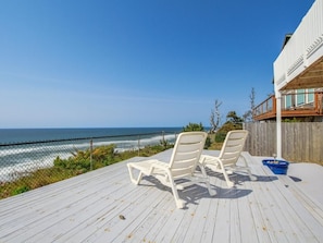 A wooden deck with two white lounge chairs facing a wooden railing overlooking the ocean. - Oceanfront Dreams~3 bedroom, 2200 square feet (Lincoln City)