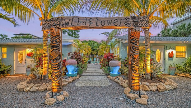Un sendero conduce a un edificio con un letrero que dice 'wildflower'.
