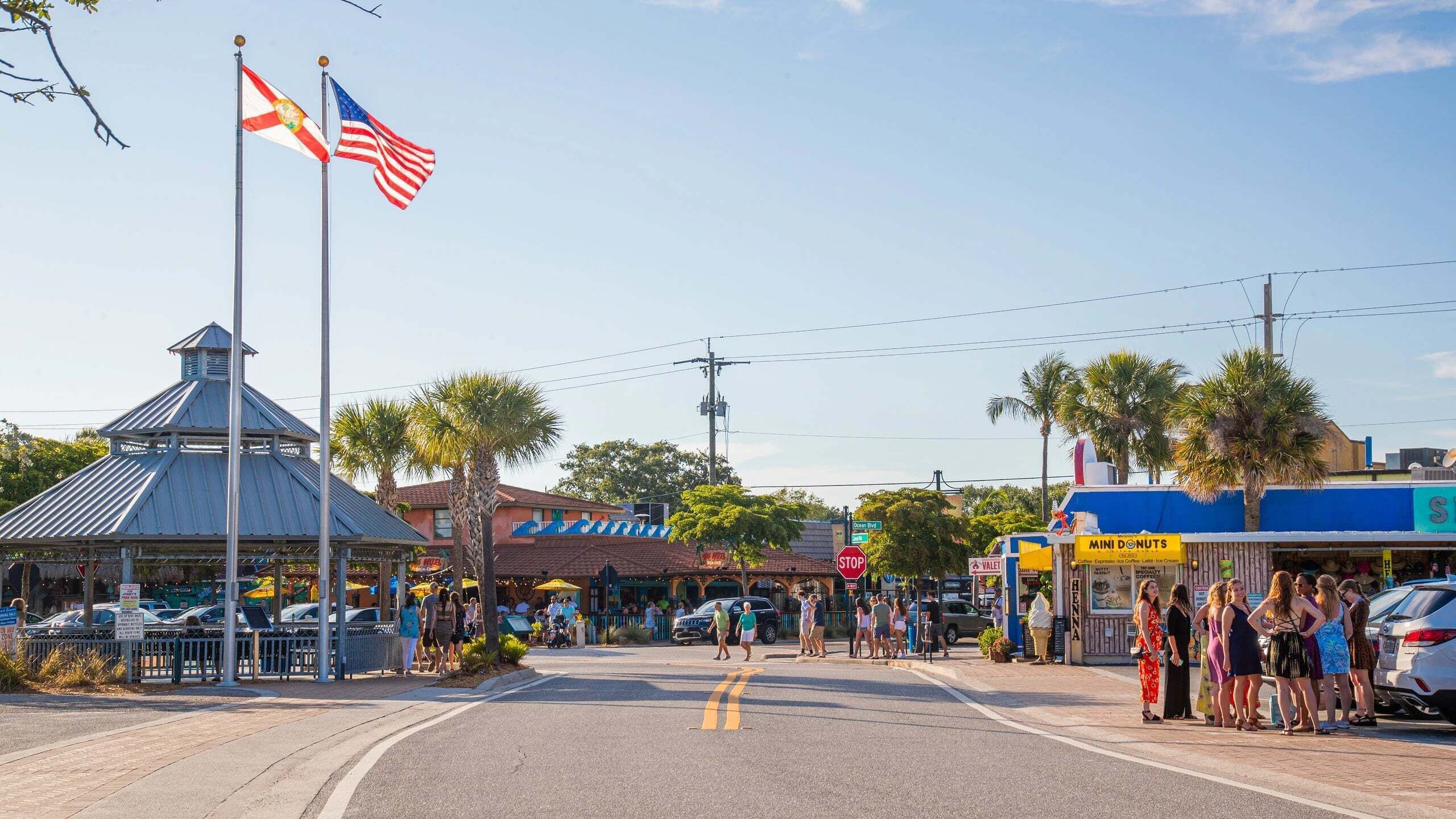 A street with shops, a gazebo, and flags.