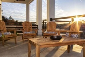 A covered outdoor seating area with wooden furniture and a view of the landscape. - Lakefront Luxury Condo w/ Fire Pit, 10 Min. to Dow (Hot Springs)
