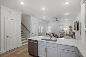 A modern kitchen with a built-in dishwasher, a large island with a sink, and a ceiling fan. - Wire Tiger-Close to Campus (Auburn)