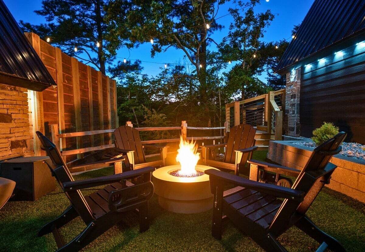 Een terras met vuurkorf, buitenmeubels en een stenen muur.