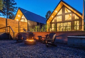 A cabin with a fire pit, outdoor seating, and large windows. - Stylish A-Frame Getaway with Pool and Lake Access (Garland County)