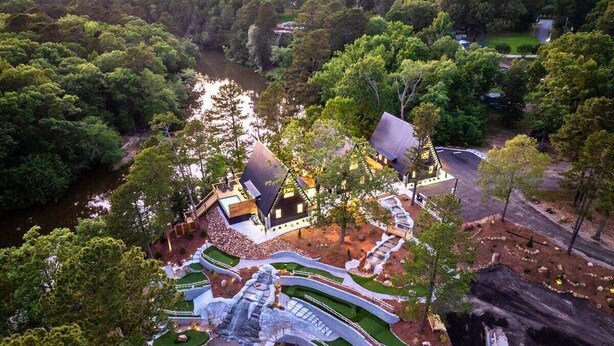 A resort with a central water feature, multiple buildings, and surrounding greenery. - 3 Side-By-Side Modern Lakefront A-Frame Cabins (Garland County)