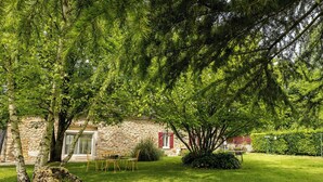 A stone building with a garden, a table with chairs, and a hedge. - 19th-century farmhouse between Troyes and Provins (Soligny-les-Étangs)