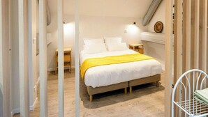 A bedroom with a bed, bedside tables, a nightstand, a wooden floor, and a sloped ceiling. - 19th-century farmhouse between Troyes and Provins (Soligny-les-Étangs)
