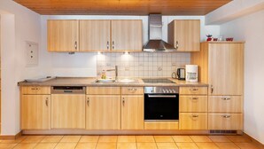 Una cucina moderna con mobili in legno, una cappa aspirante in acciaio inossidabile e un forno integrato.