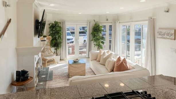 Ein großzügiger Wohnbereich mit einer Couch, einem Couchtisch und einer Treppe zu einer oberen Etage.