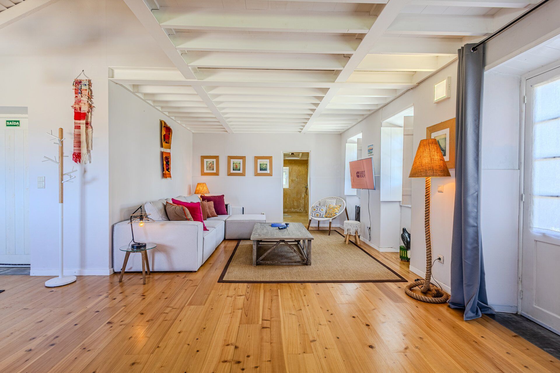 A spacious living area with a sofa, a coffee table, a lamp, and a chair.