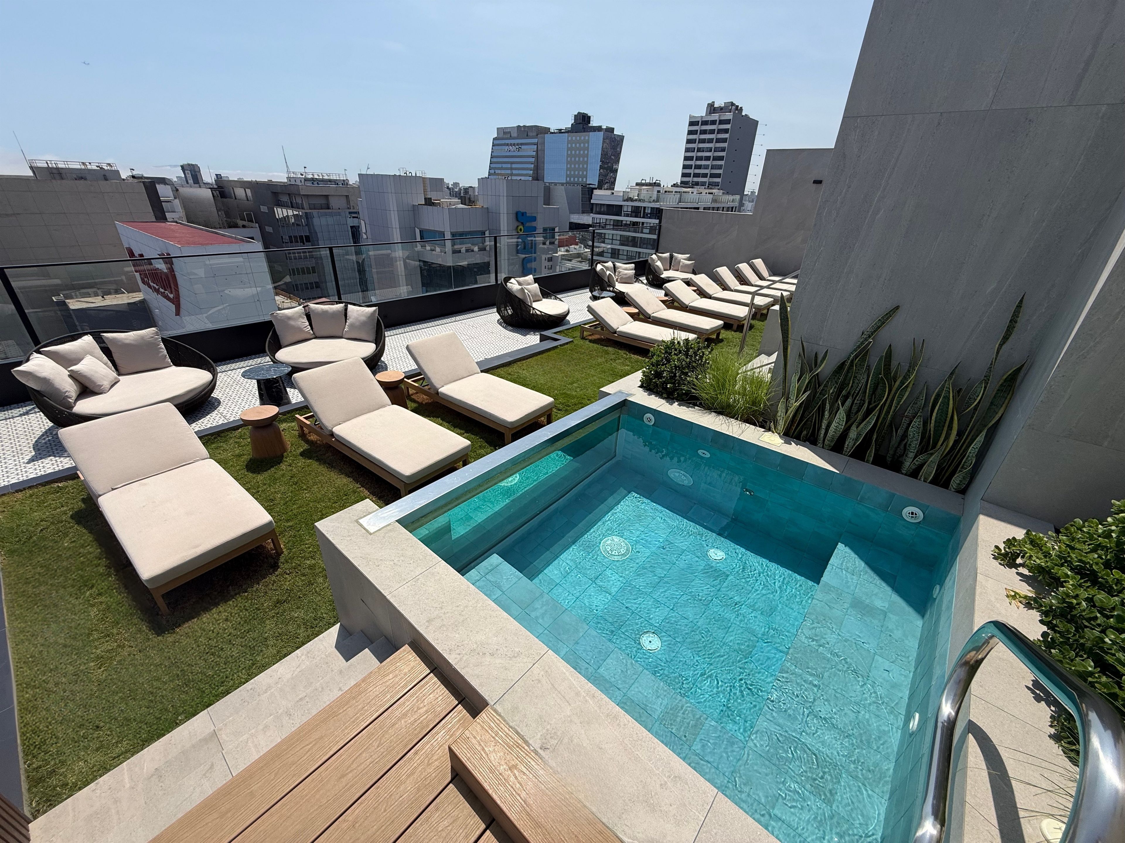 A rooftop pool area with lounge chairs and a swimming pool.