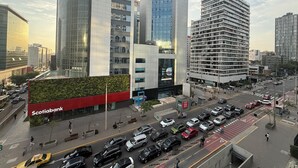Une rue moderne, située en plein centre-ville, bordée d’immeubles de grande hauteur, dont un bâtiment abritant une banque importante et plusieurs immeubles de bureaux.