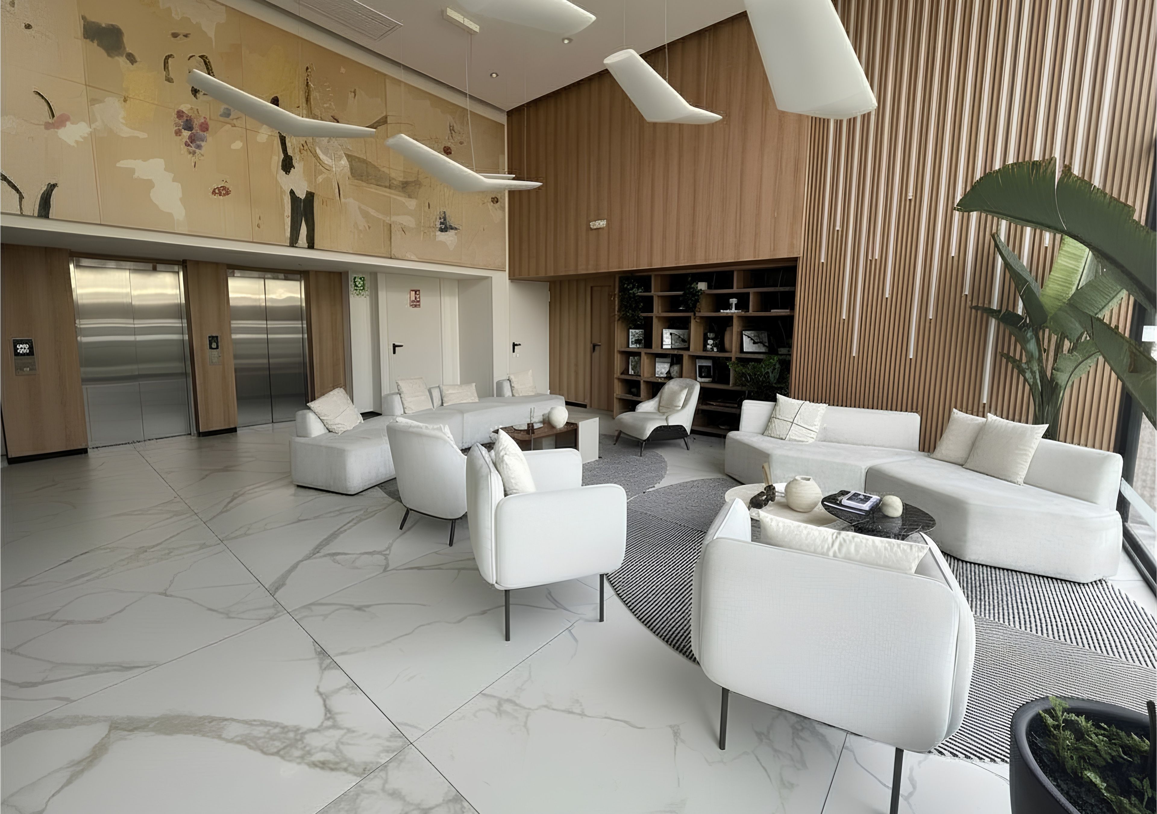 Un vestíbulo moderno con piso de mármol, sofás blancos, una mesa de centro y una estantería.