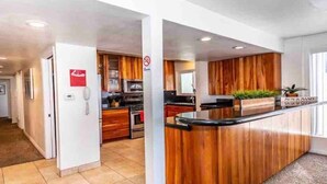 Een moderne keuken met houten kastjes, een centraal eiland en een ingebouwde magnetron.
