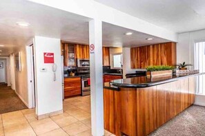Una cocina moderna con armarios de madera, una isla central y un microondas integrado.