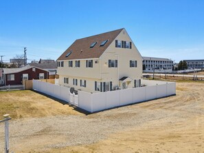 A two-story building with a sloped roof, multiple windows, and a fenced perimeter. - Spacious 5-bedroom WAVES OF HAMPTON I & II Combined (Hampton)