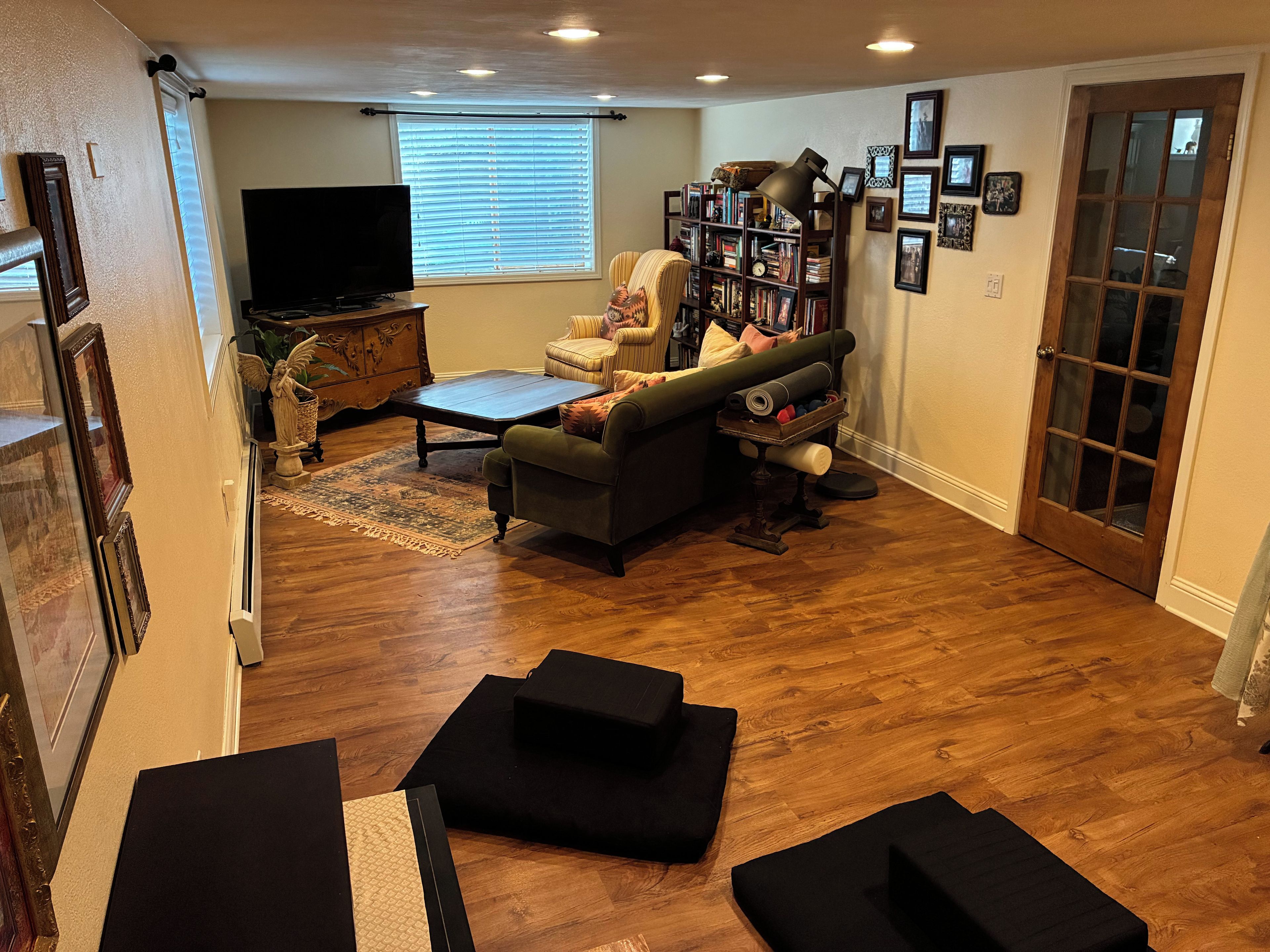 A living room with a sofa, a coffee table, a bookshelf, and a television.