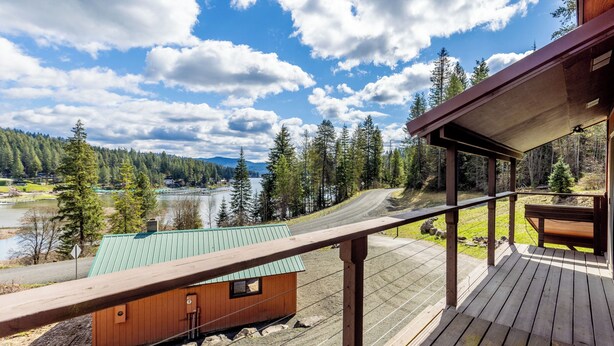 Una terraza de madera con vistas a un lago y un bosque.