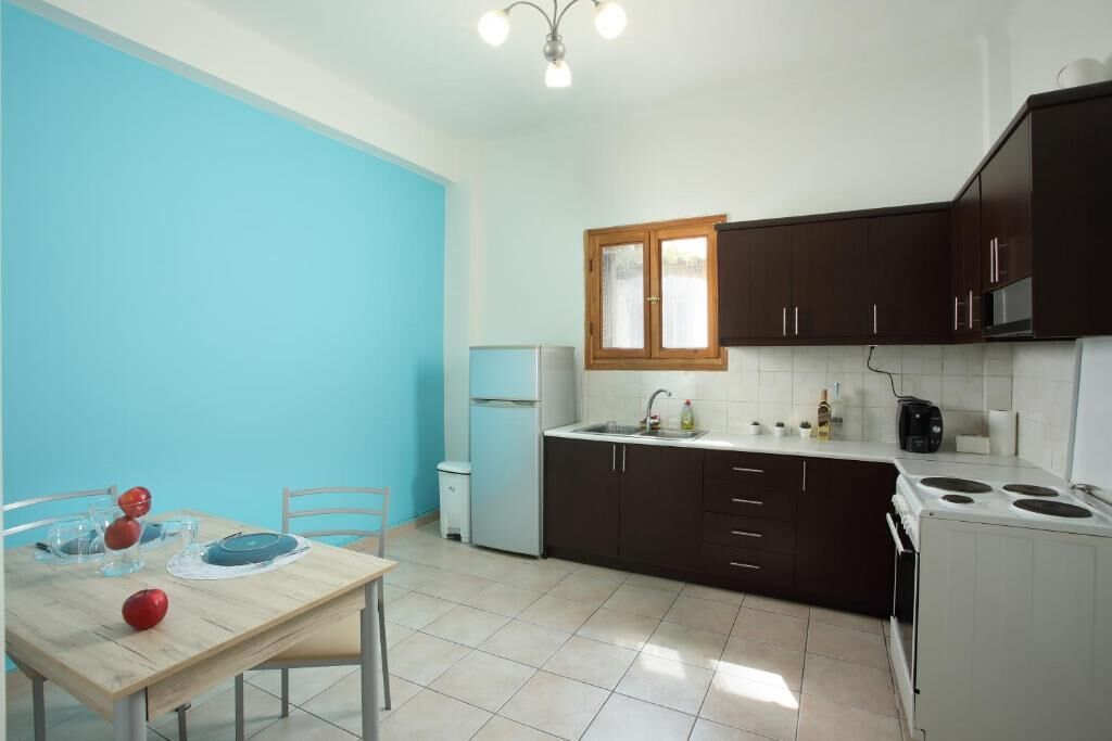 A kitchen with dark cabinets, a white stove, and a blue wall.