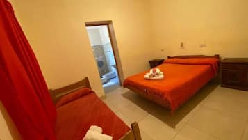 A room with two beds, a wooden headboard, a red curtain, and a small wooden nightstand.